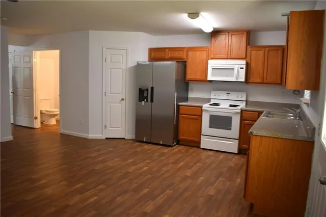 a kitchen with stainless steel appliances granite countertop a refrigerator stove top oven a sink and dishwasher