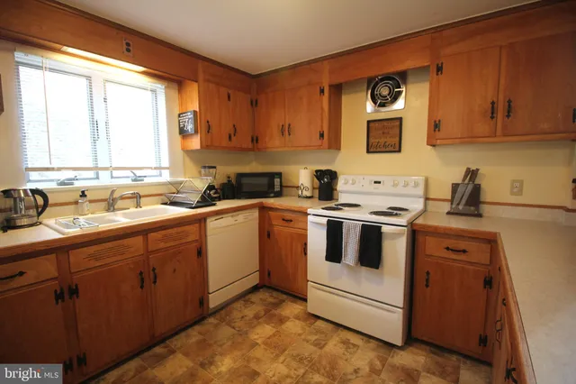 a kitchen with a sink cabinets appliances and a window