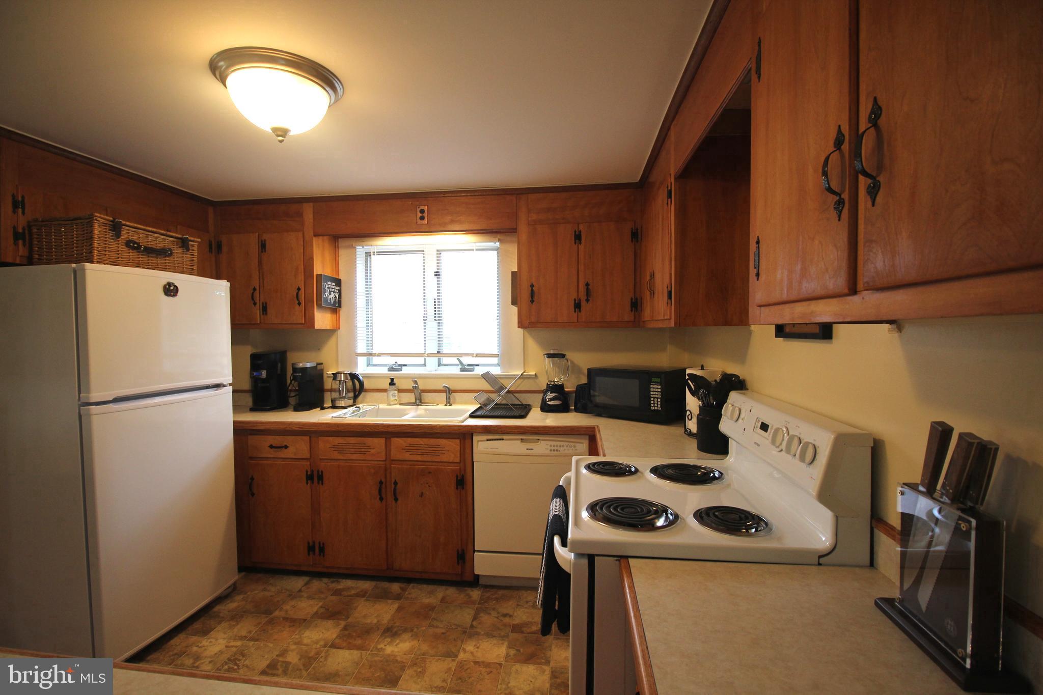 48 Poor Farm Road, Unit COTTAGE Pennington, NJ 08534 - Photo 13 of 34 a kitchen with a sink a refrigerator and a stove