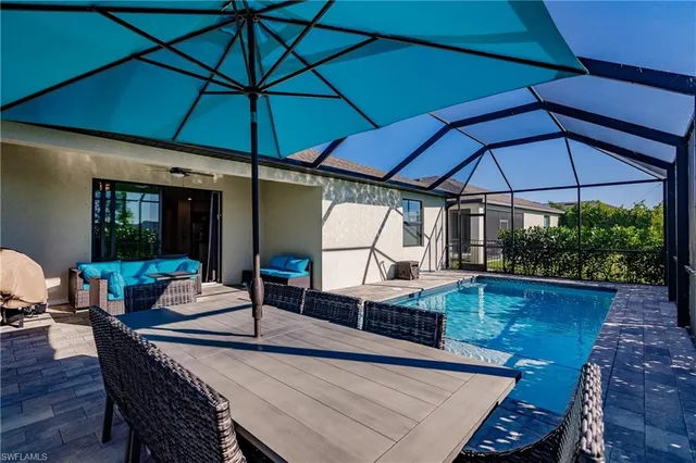 a view of a patio with table and chairs under an umbrella