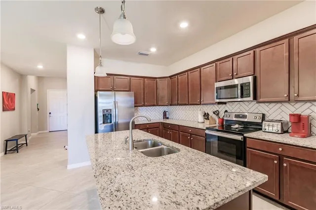 a kitchen with stainless steel appliances granite countertop a sink a stove a microwave a center island and cabinets