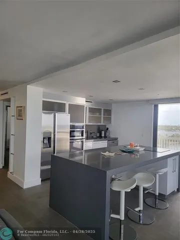 a kitchen with stainless steel appliances granite countertop a sink and a refrigerator