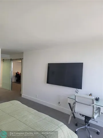 a bedroom with a chair and a bookshelf
