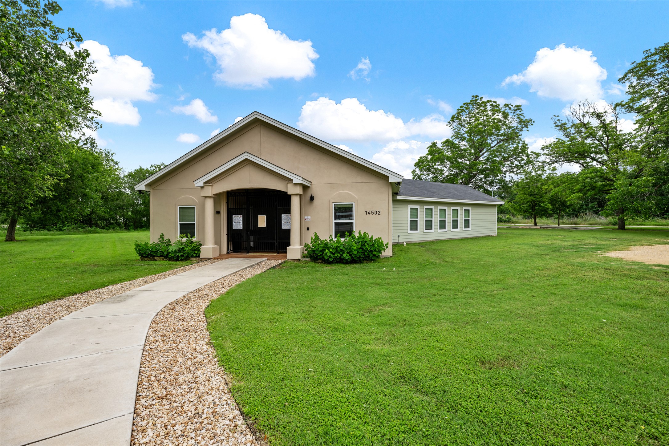 14900 Retha Pass Austin, TX 78725 - Photo 35 of 39 Stucco exterior featuring a covered entry, gabled roofline, and multiple windows