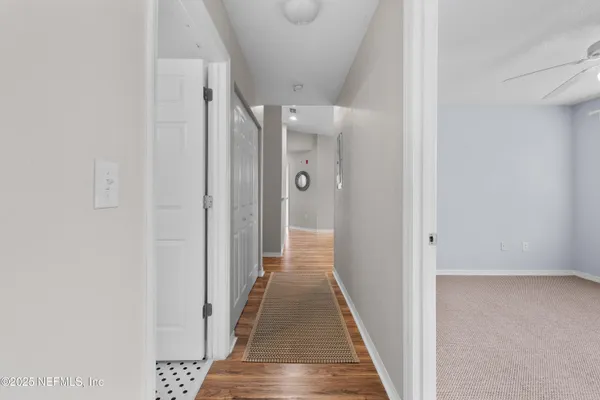 a view of a hallway with wooden floor and staircase