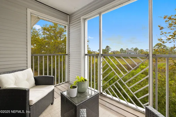 a view of a balcony with couches and potted plants
