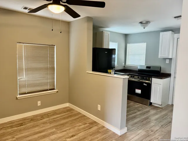 a living room with stainless steel appliances kitchen island granite countertop a stove and a microwave