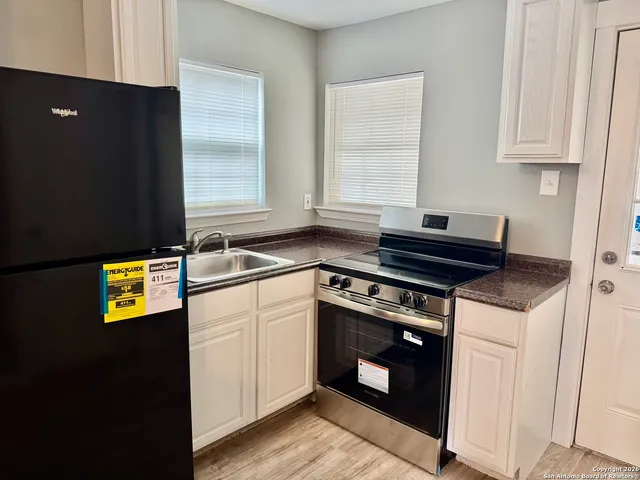 a kitchen with stainless steel appliances granite countertop a stove a microwave and a refrigerator