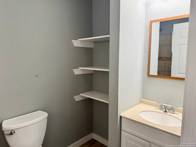 a bathroom with a toilet sink and mirror