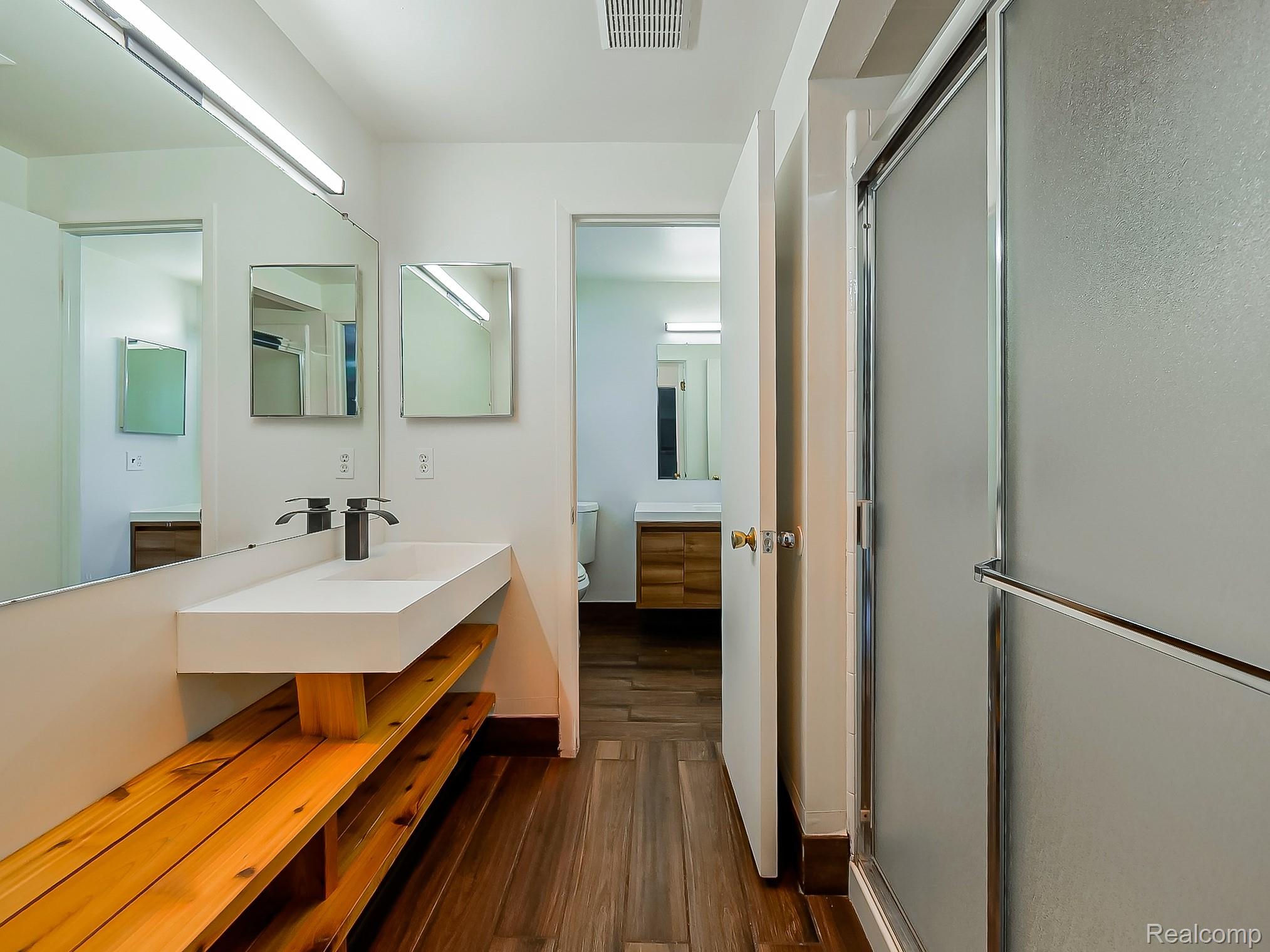 42195 Park Ridge Road Novi, MI 48375 - Photo 31 of 52 Modern vanity with an integrated basin, matte black faucet, and wood-finish open shelving