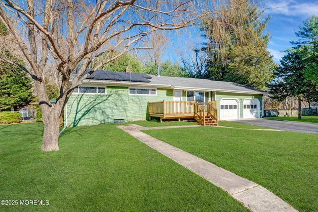 a view of a house with a yard and sitting area