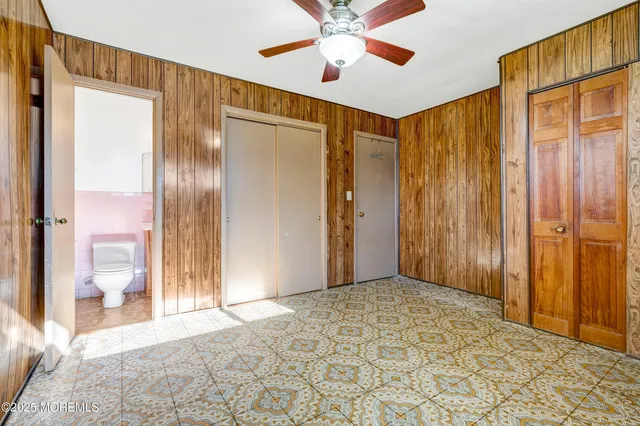 a view of a hallway with a chandelier fan and windows