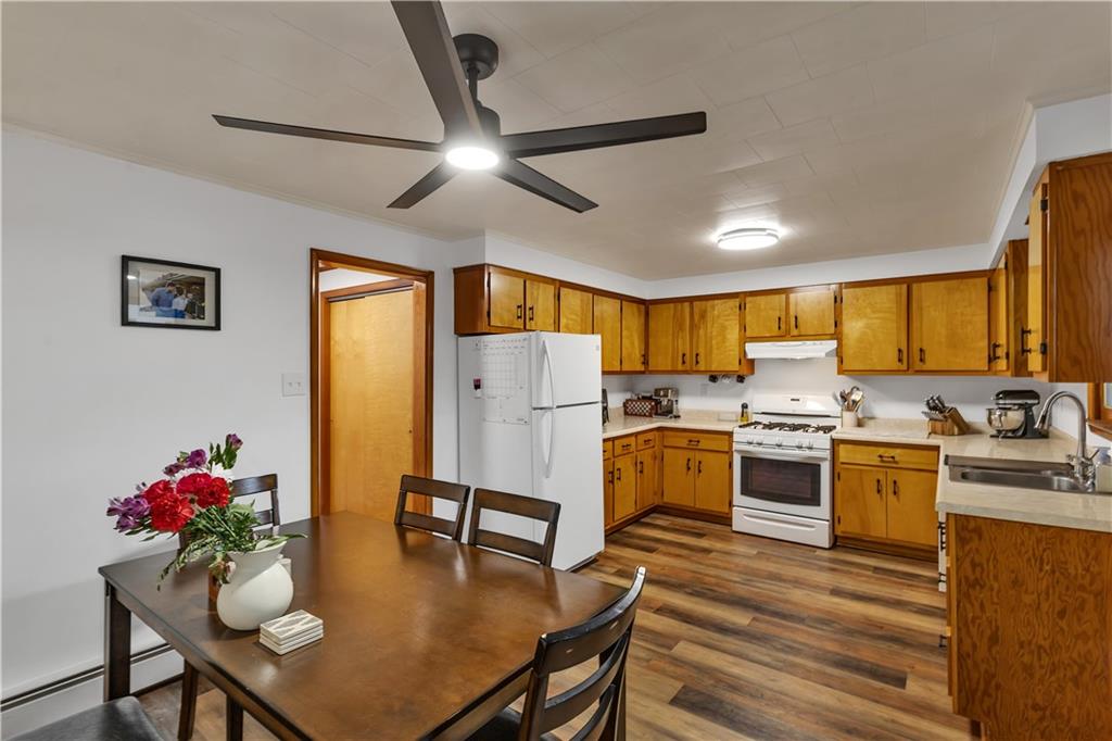 156 Manor Road Delmont, PA 15626 - Photo 10 of 32 17x11 Eat in Kitchen with Natural Birch Wood Cabinetry, Neutral Counters and Ceiling Fan over Dining Area.