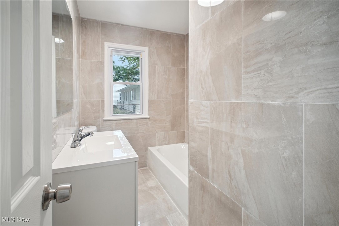8796 West Ridgewood Drive Cleveland, OH 44130 - Photo 23 of 38 Bathroom featuring vanity and tile walls