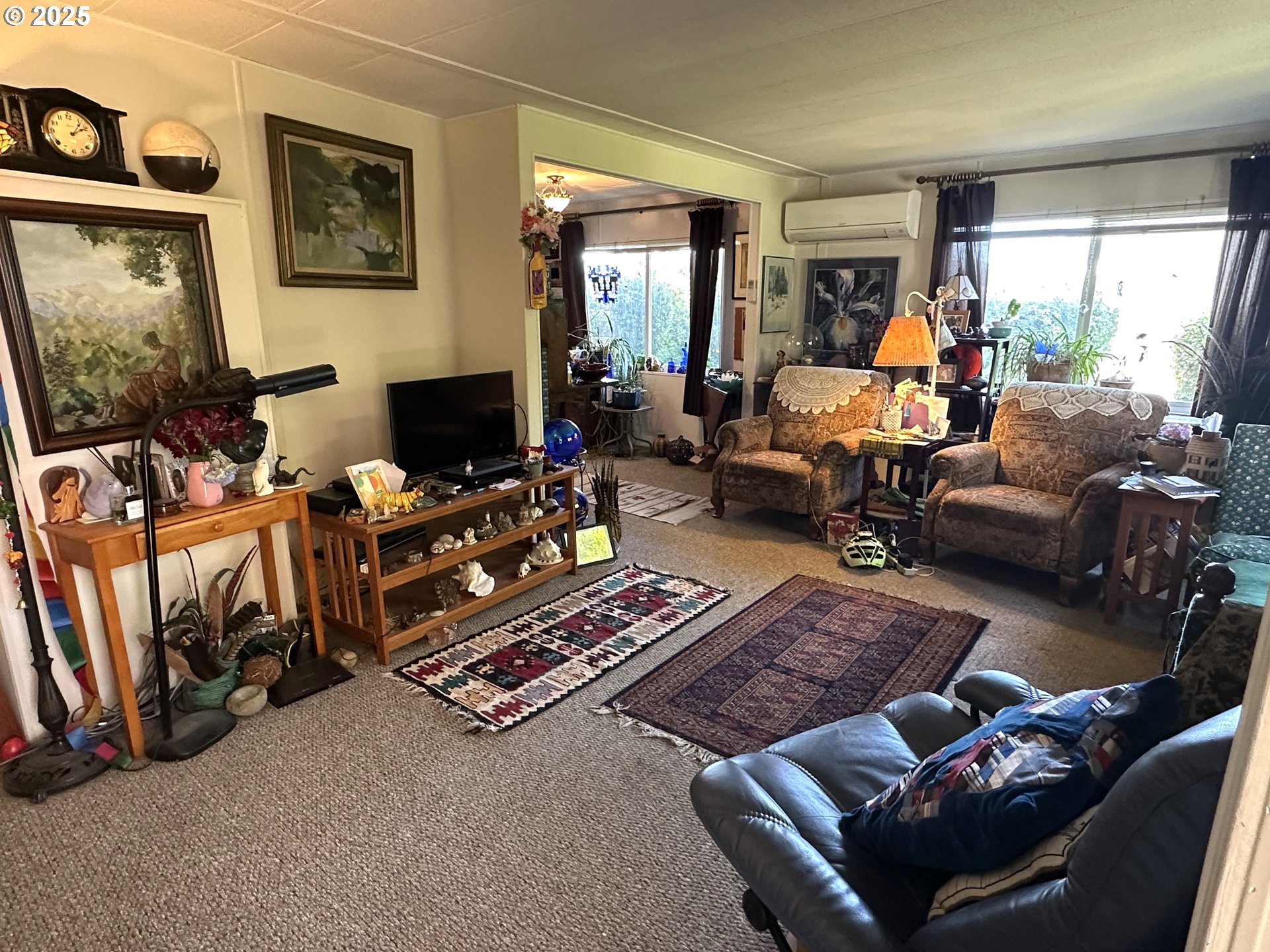 1601 Rhododendron Drive, Unit 572 Florence, OR 97439 - Photo 5 of 31 a living room with furniture a flat screen tv and a floor to ceiling window