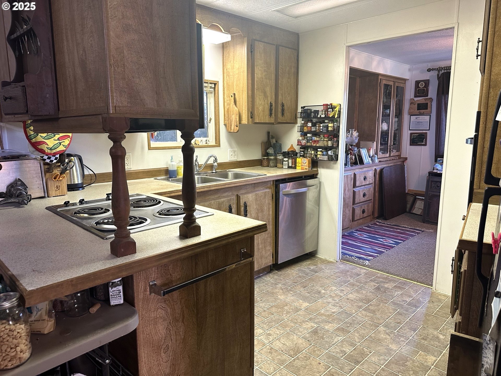 1601 Rhododendron Drive, Unit 572 Florence, OR 97439 - Photo 8 of 31 a kitchen with kitchen island granite countertop a sink stove and cabinets