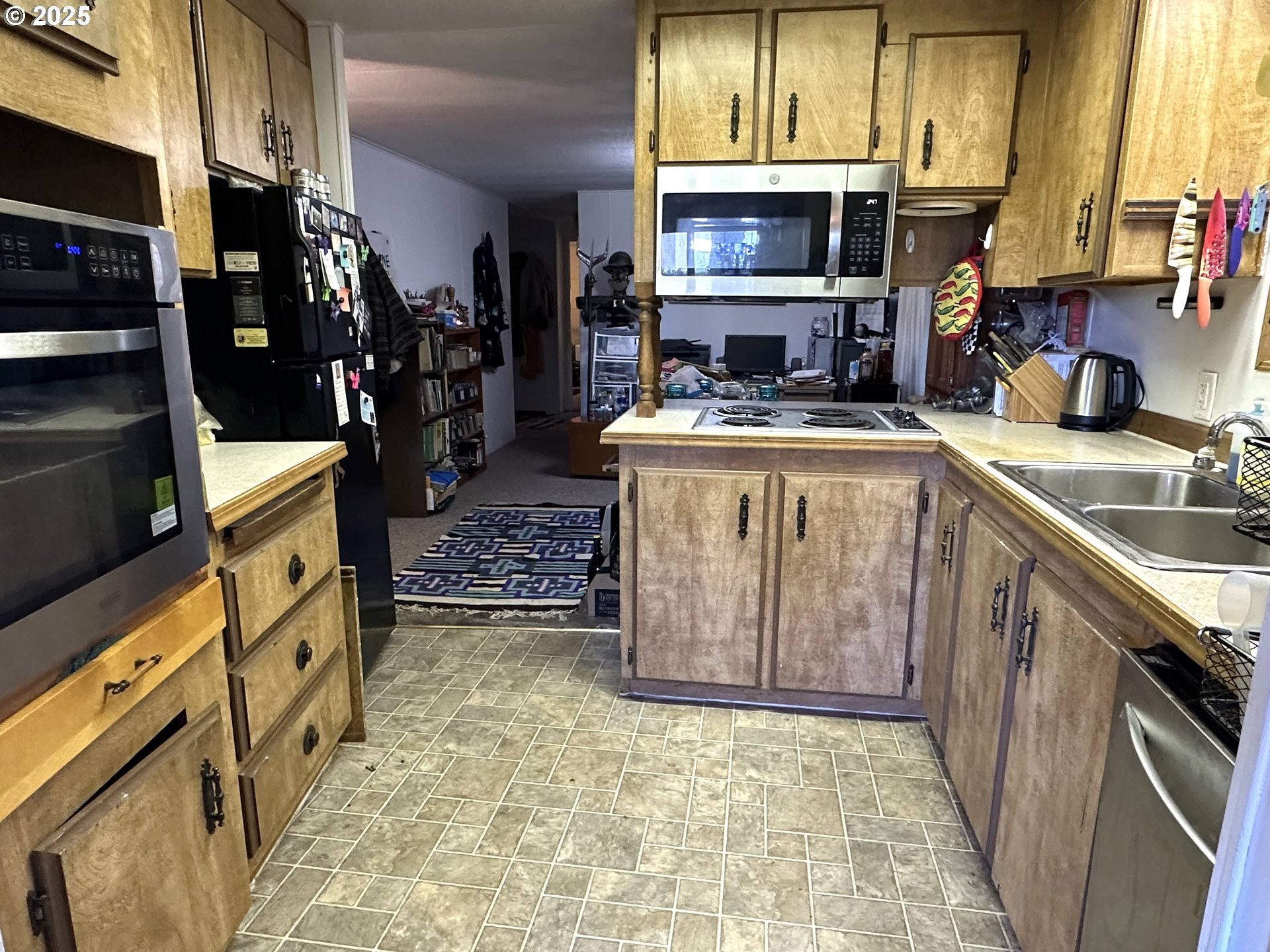 1601 Rhododendron Drive, Unit 572 Florence, OR 97439 - Photo 10 of 31 a kitchen with stainless steel appliances granite countertop a stove a sink and a microwave