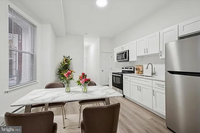 a kitchen with granite countertop a sink appliances and cabinets