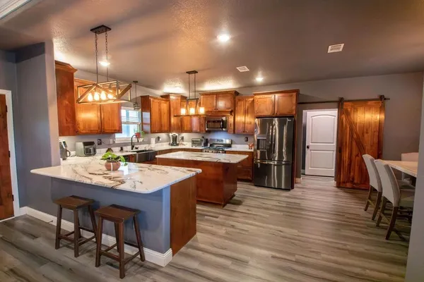 a kitchen with stainless steel appliances granite countertop a sink refrigerator and cabinets