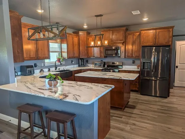 a kitchen with stainless steel appliances granite countertop sink stove top oven and refrigerator