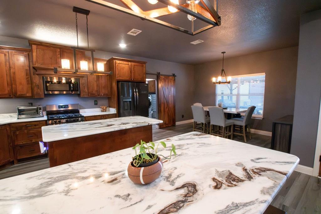 1144 Alamo Road Montague, TX 76251 - Photo 14 of 26 a kitchen with stainless steel appliances kitchen island granite countertop a sink and cabinets
