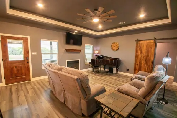 a living room with fireplace furniture and a wooden floor