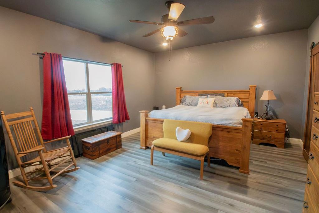 1144 Alamo Road Montague, TX 76251 - Photo 18 of 26 a bedroom with furniture and wooden floor