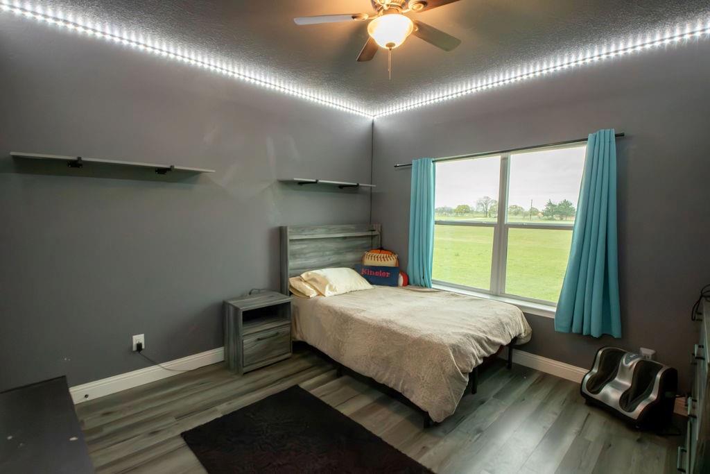 1144 Alamo Road Montague, TX 76251 - Photo 22 of 26 a bedroom with a bed and a chandelier