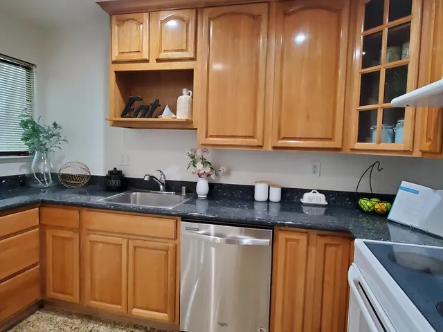 a kitchen with stainless steel appliances granite countertop a sink a stove and cabinets