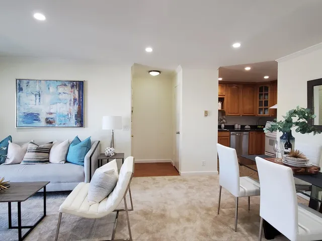 a living room with furniture and kitchen view