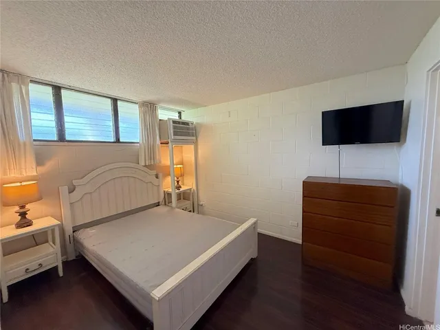 a bedroom with a bed and a flat screen tv