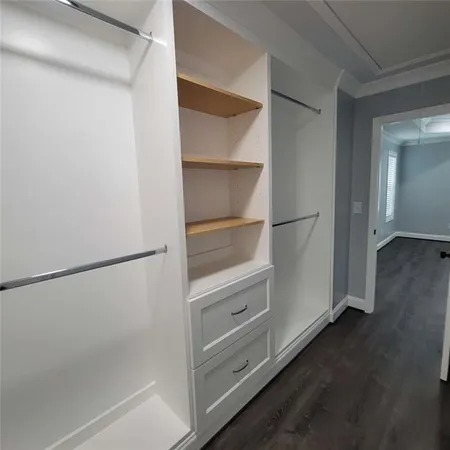 a view of walk in closet with empty racks