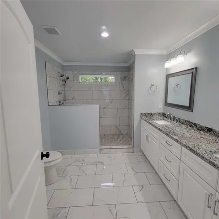 a spacious bathroom with a granite countertop sink a toilet and a mirror