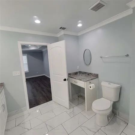 a bathroom with a granite countertop toilet and a sink
