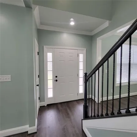 a view of a hallway with wooden floor and entryway