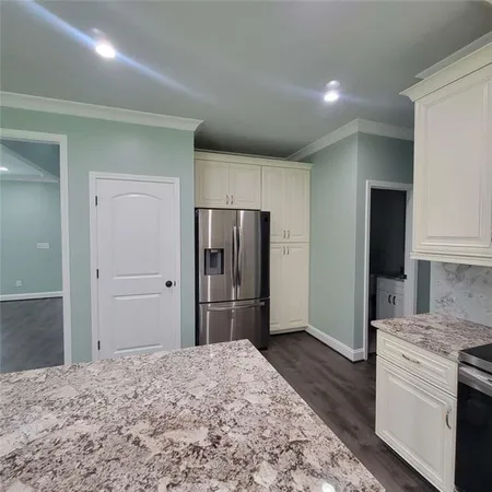 a kitchen with stainless steel appliances granite countertop a refrigerator and a stove top oven