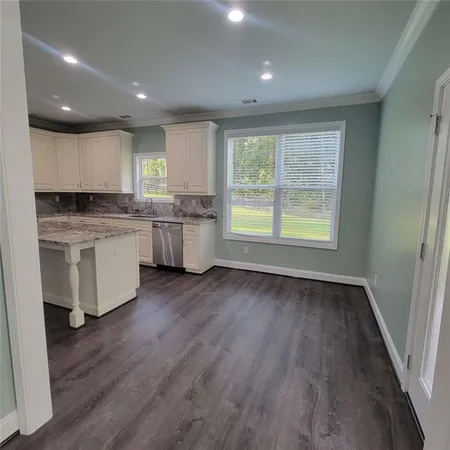 a kitchen with a sink a window and wooden floor