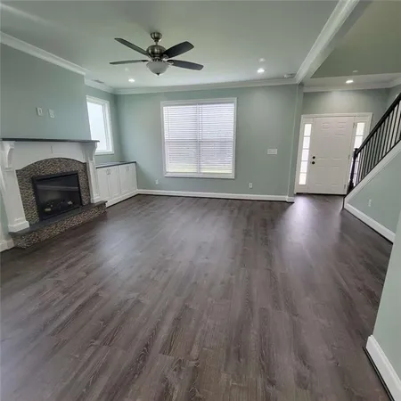 an empty room with wooden floor a fireplace and windows