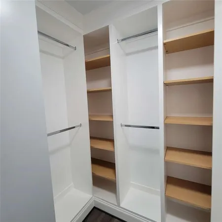 a view of walk in closet with empty racks