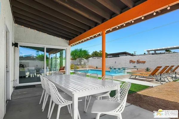 a patio with glass top table and chairs