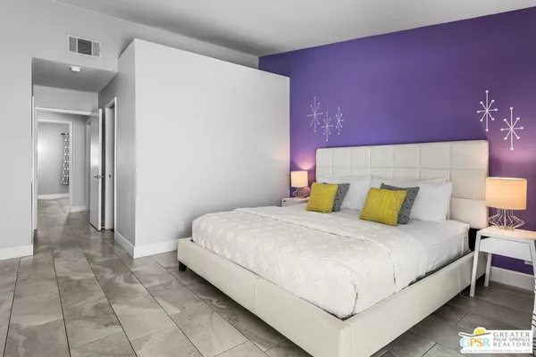 a bedroom with a bed and a lamp