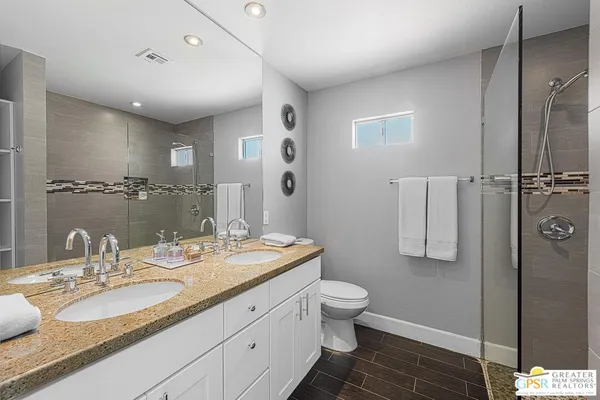 a bathroom with a granite countertop sink toilet and shower