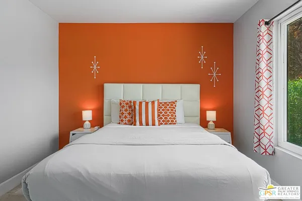 a large bed sitting in a bedroom next to a lamp