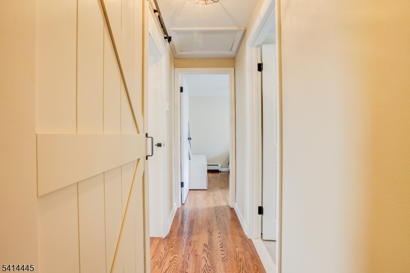 46 Walnut Street Pompton Lakes, NJ 07442 - Photo 12 of 22 a view of a hallway with white walls and wooden floor