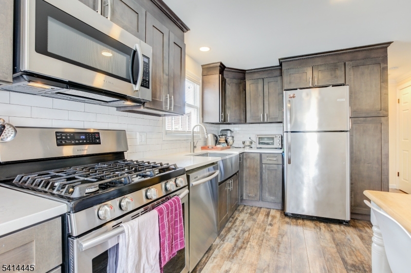 46 Walnut Street Pompton Lakes, NJ 07442 - Photo 8 of 22 a kitchen with stainless steel appliances granite countertop a stove a refrigerator and a microwave