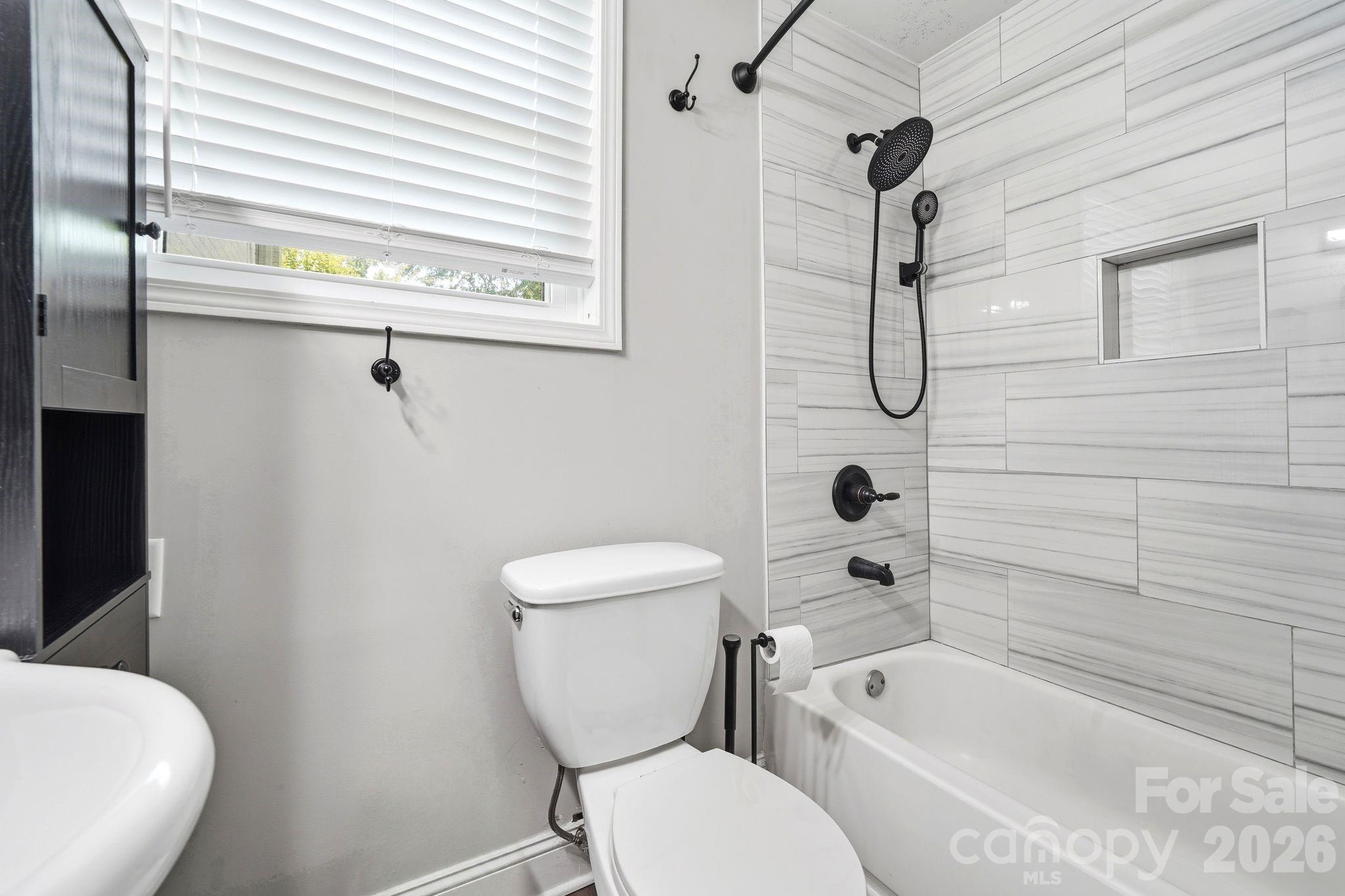 7552 Idlewild Road Charlotte, NC 28212 - Photo 20 of 40 a bathroom with a toilet a sink and bathtub