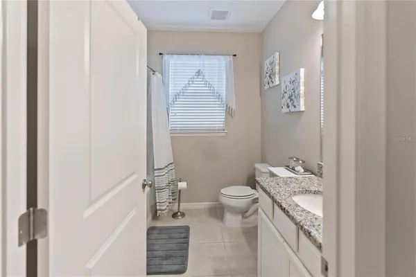a bathroom with a granite countertop sink a toilet and a mirror