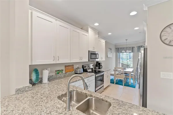 a kitchen with stainless steel appliances granite countertop a sink refrigerator and cabinets