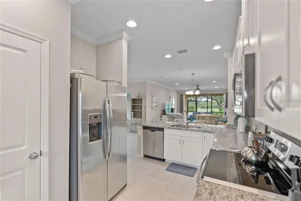 a kitchen with stainless steel appliances granite countertop a sink and a refrigerator