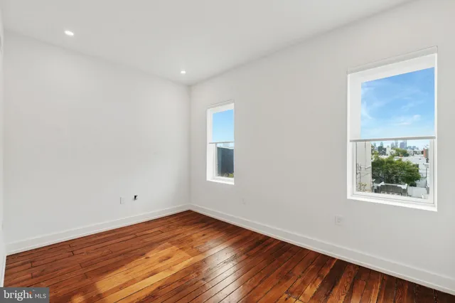 a view of a room with wooden floor and window